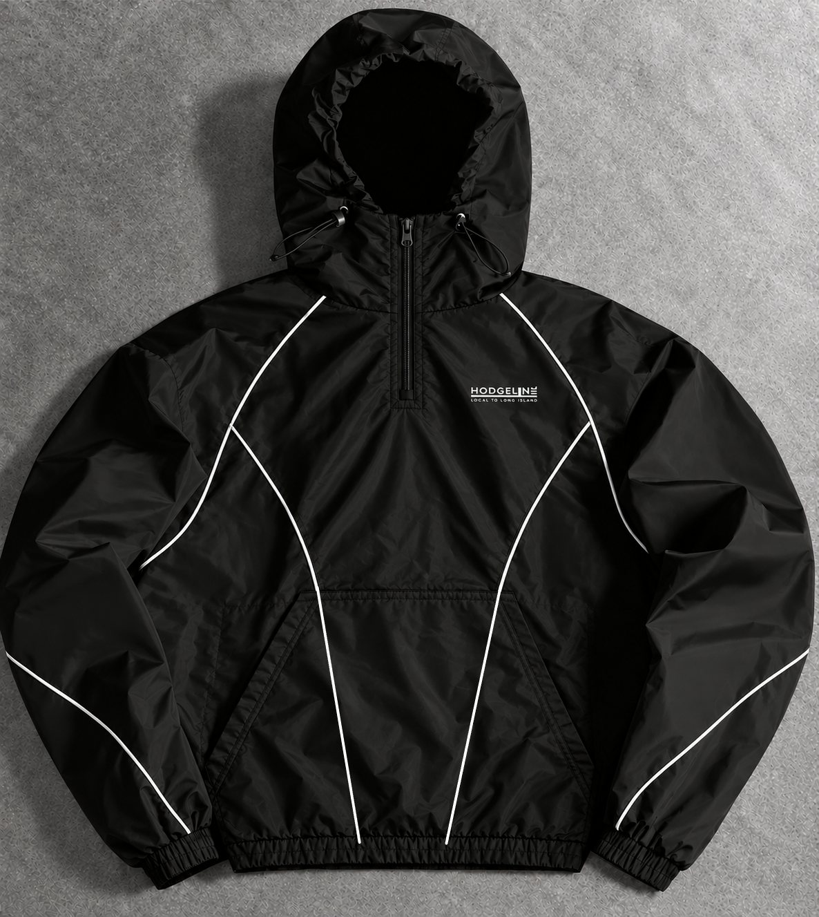 The Hodgeline Shell, a black waterproof half zip with a built-in hood and white piping